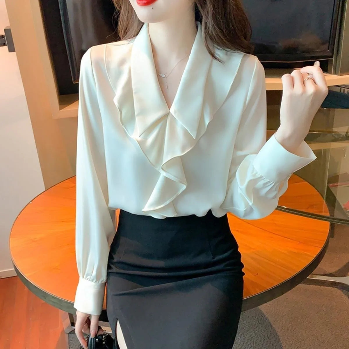 Ladies white chiffon blouse with long sleeves on a plain background