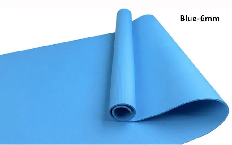 Red EVA yoga mat showing thickness, next to a blue mat, on a wooden floor.