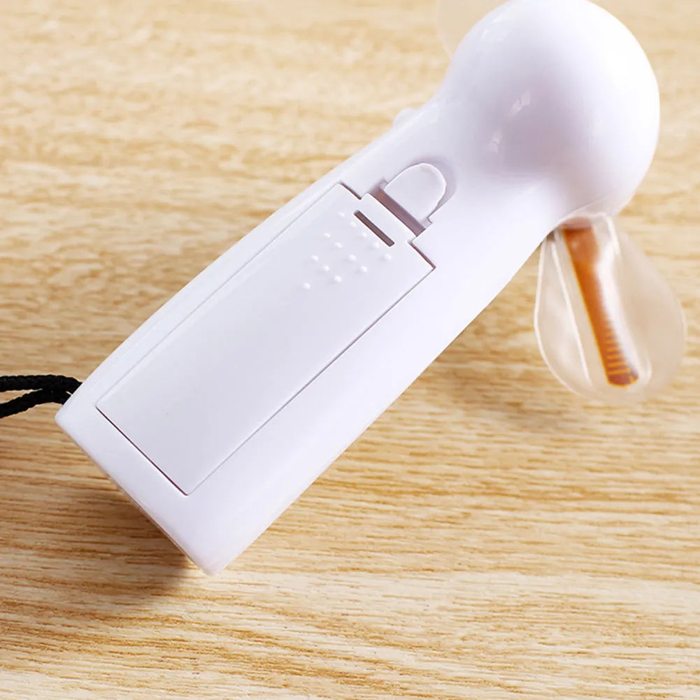 White handheld mini fan displaying a red flashing 'I Love You' LED pattern on its front panel.