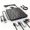 Black portable external USB CD/DVD drive and writer on a desk next to a laptop