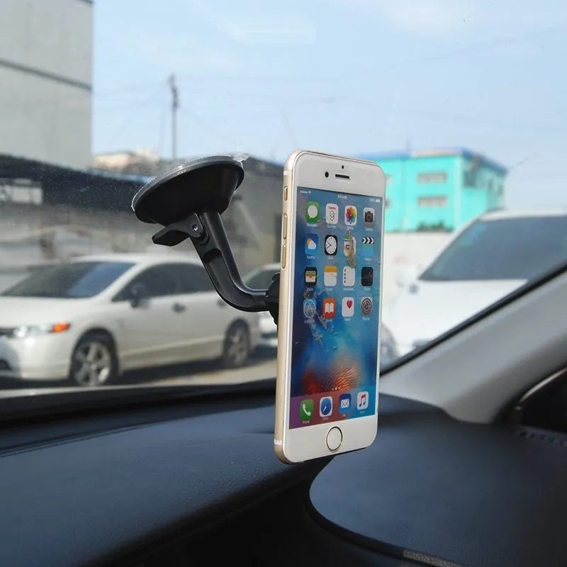 Black magnetic car phone holder mounted on dashboard with smartphone attached showing 360-degree rotation feature