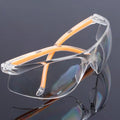 Transparent polycarbonate safety goggles with yellow frame for industrial and lab eye protection.