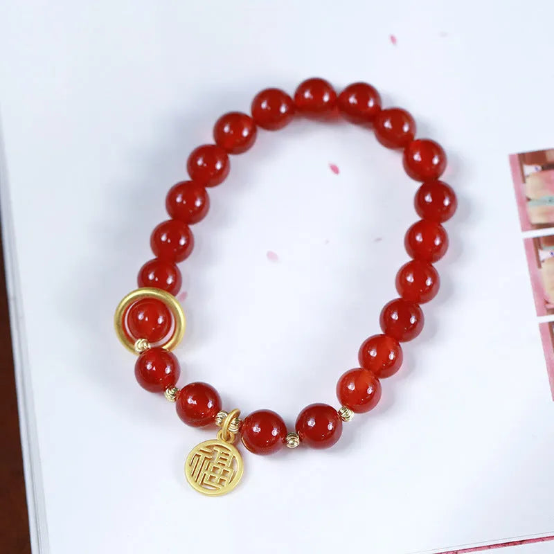 Natural red agate bracelet with woven bead design on a wrist.