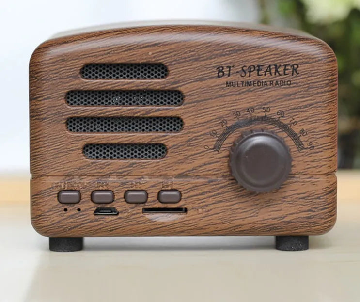Vintage-style Bluetooth speaker with wood grain finish, showing compact size and front speaker grill.