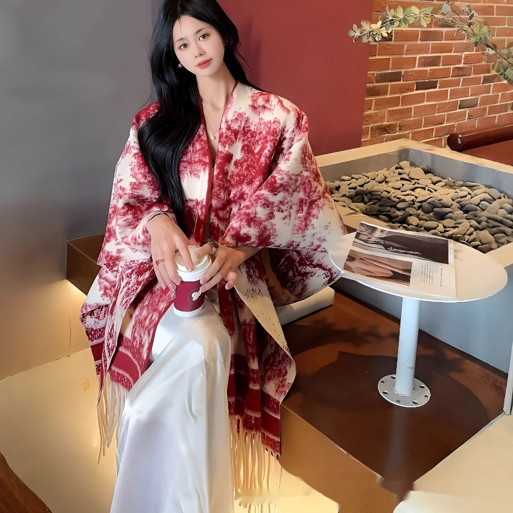 Women's polyester scarf cape with tassel fringe in a printed floral design, worn as a shawl.