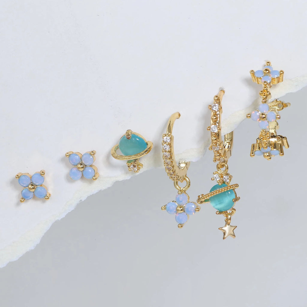 Gold and silver flower-shaped ear studs with zircon mosaic detail on a white background.