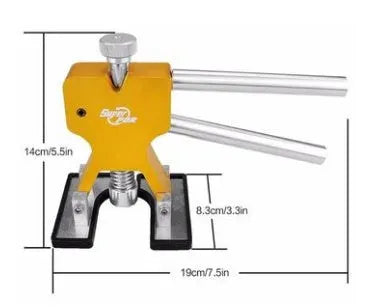 Car dent removal kit with gold puller, rubber tabs, glue gun, and shovel scoops on a workbench
