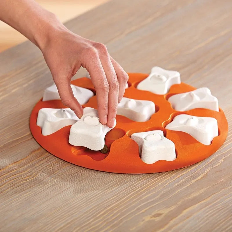 Orange and white plastic leak food puzzle toy for dogs and cats with kibble falling from opening