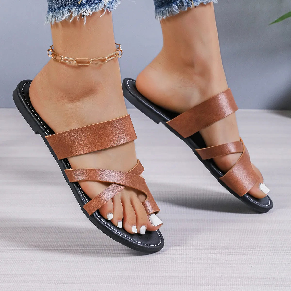 Black casual beach slipper with hollow-out design and rubber sole.