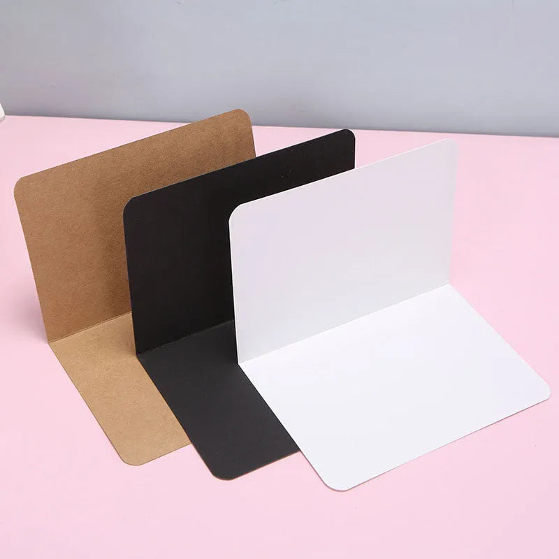 Pack of 100 blank folded kraft cards in 10x15cm size on a craft table