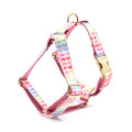 Pink colourful dog chest and back harness with gold buckle and heart-shaped stone details.