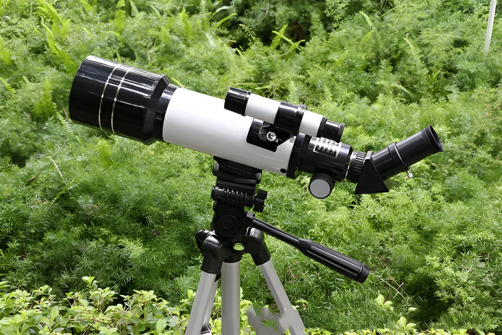 Dark blue children's astronomical monocular telescope on a tripod with optional mobile phone holder attached.