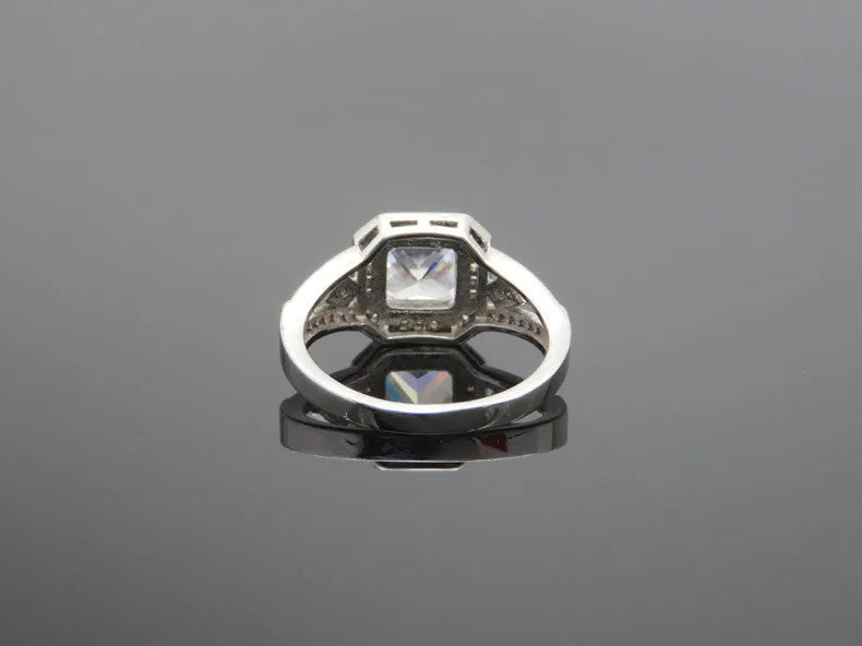 Women's platinum colour geometric zircon ring with hollow quadrilateral design on a copper band.