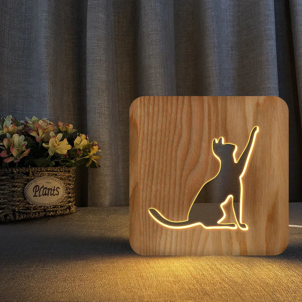 Solid wood cat-shaped 3D night light with hollow silhouette, lit with warm glow.
