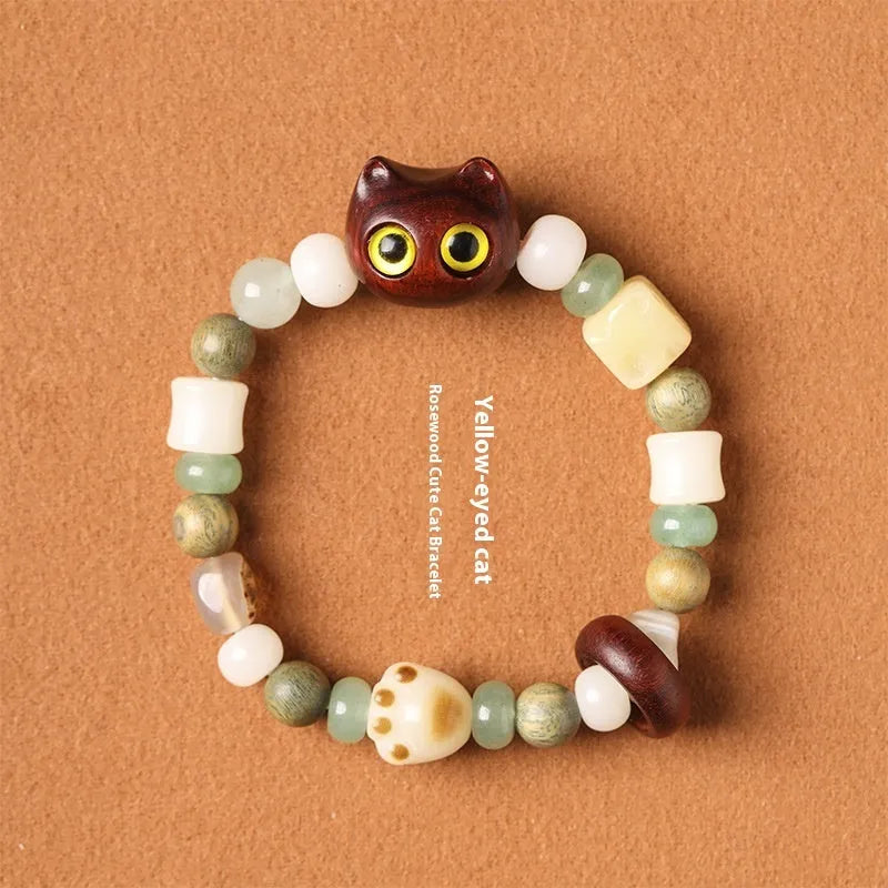 Hand-woven beaded bracelet with bodhi, jade, and ebony beads featuring a cartoon cat's paw charm.