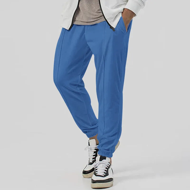 Men's grey straight-leg track sweatpants with a mid-waist, showcasing a relaxed fit and casual style.