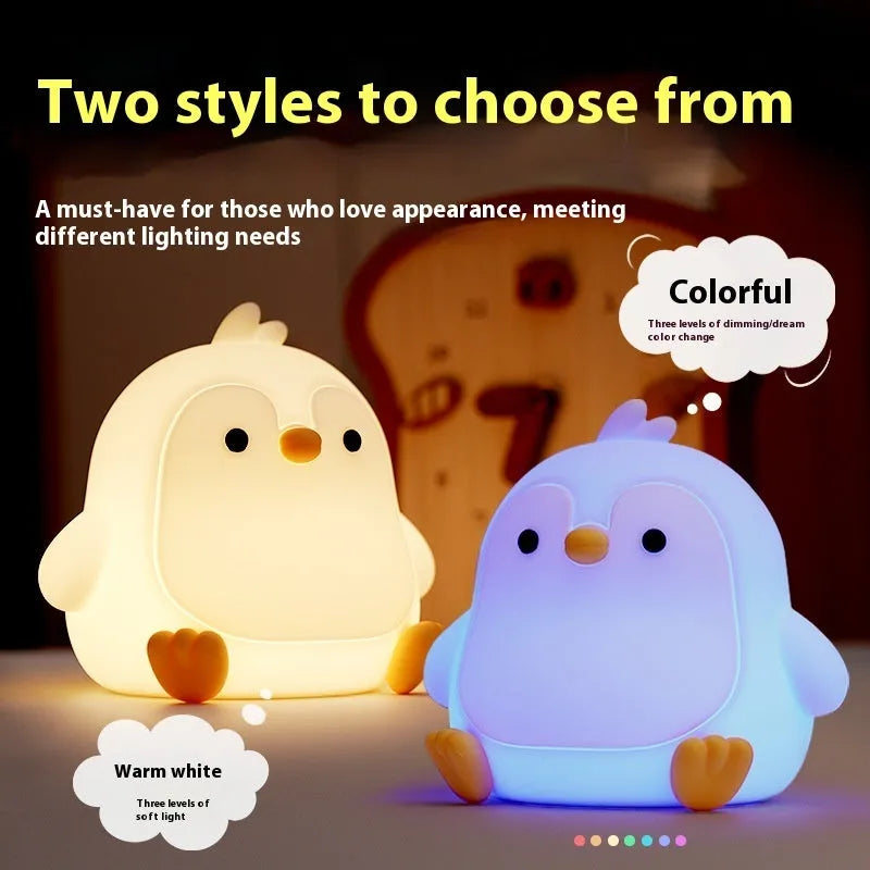 Baby penguin silicone small night lamp in black with warm light mode on bedside table
