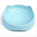 Blue ceramic dog slow feeder bowl with internal maze design, shown next to a green and pink version.