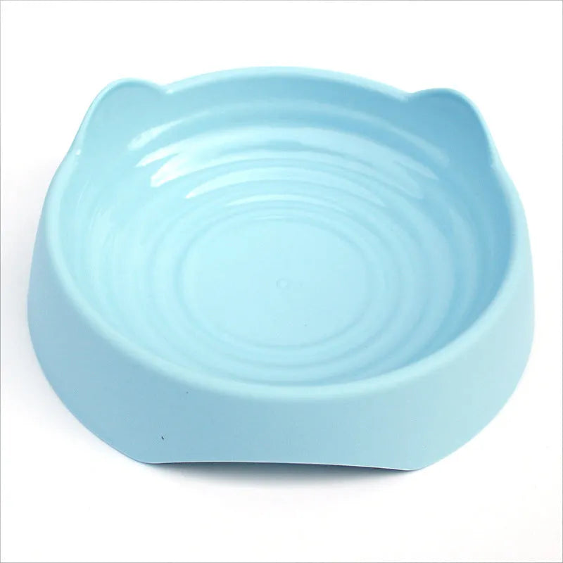 Blue ceramic dog slow feeder bowl with internal maze design, shown next to a green and pink version.