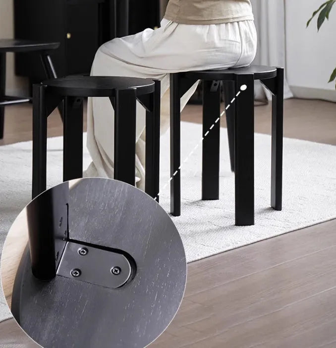 A single modern stackable iron dining stool with a round seat in a cream colour, showing its tubular steel frame.