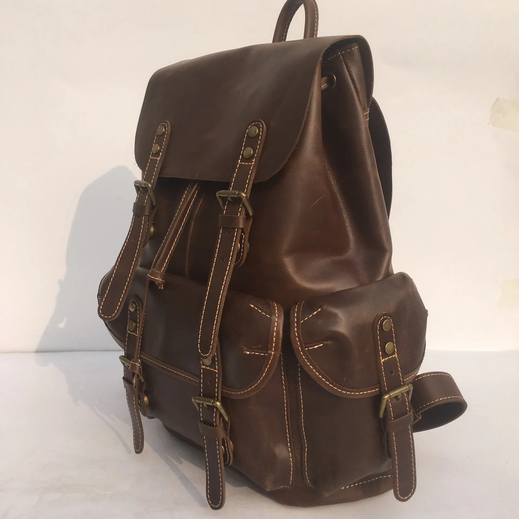Brown leather men's backpack with shoulder straps showing cowhide leather texture