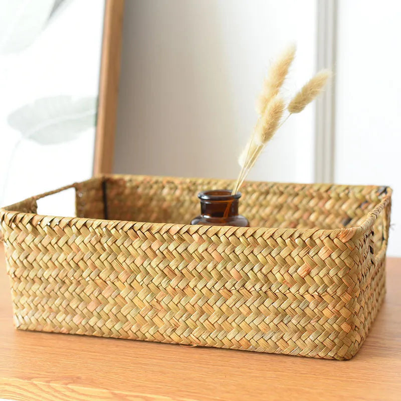 Handwoven grass rectangular storage baskets in various sizes on a wooden shelf
