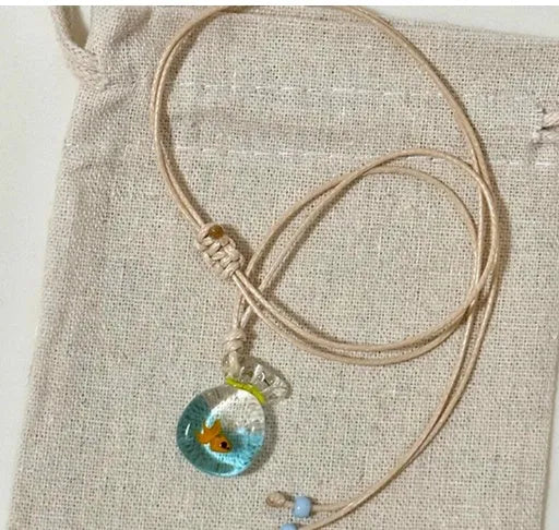 Women's necklace with a colourful skirt joker pendant on a long, braided cotton and linen chain.