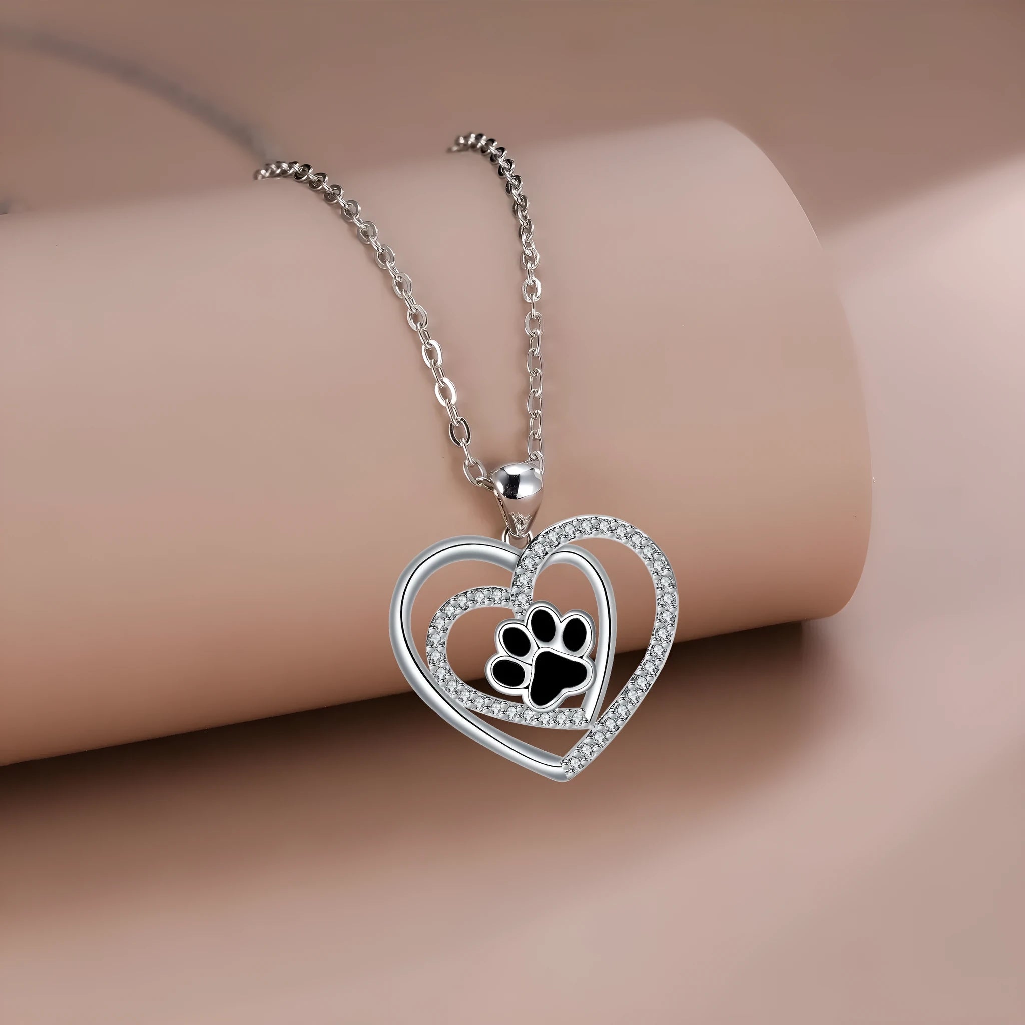 Women's copper necklace with dog paw print and heart detail pendant on cross chain.