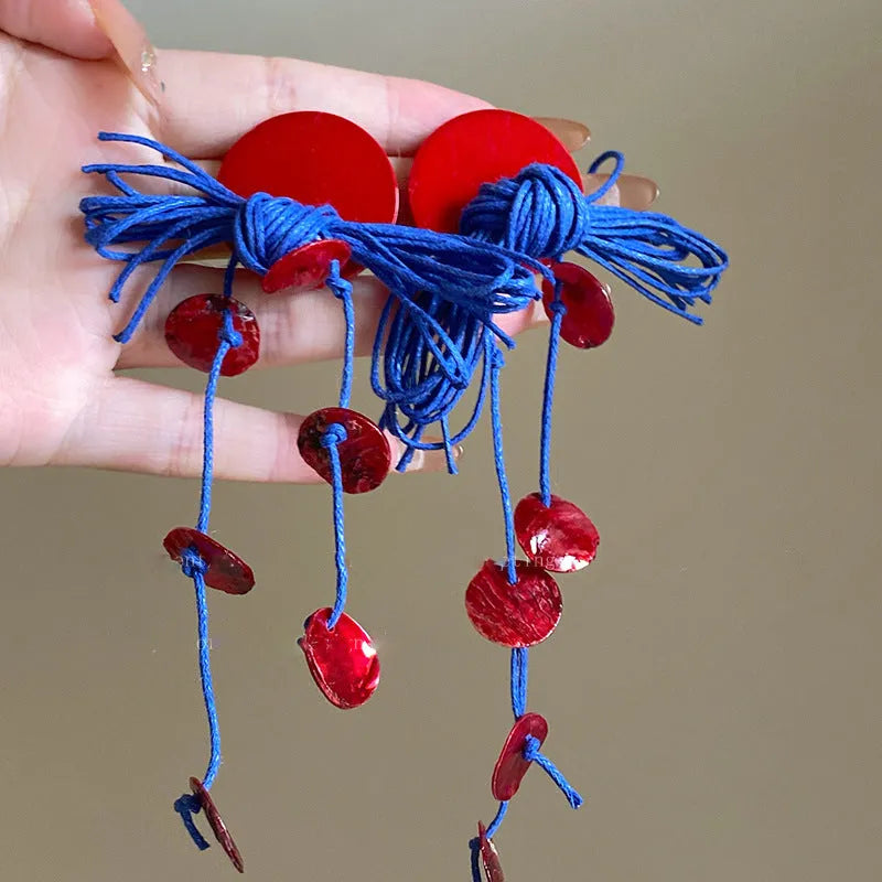 Geometric women's earrings made from blue and silver cloth with round design elements.