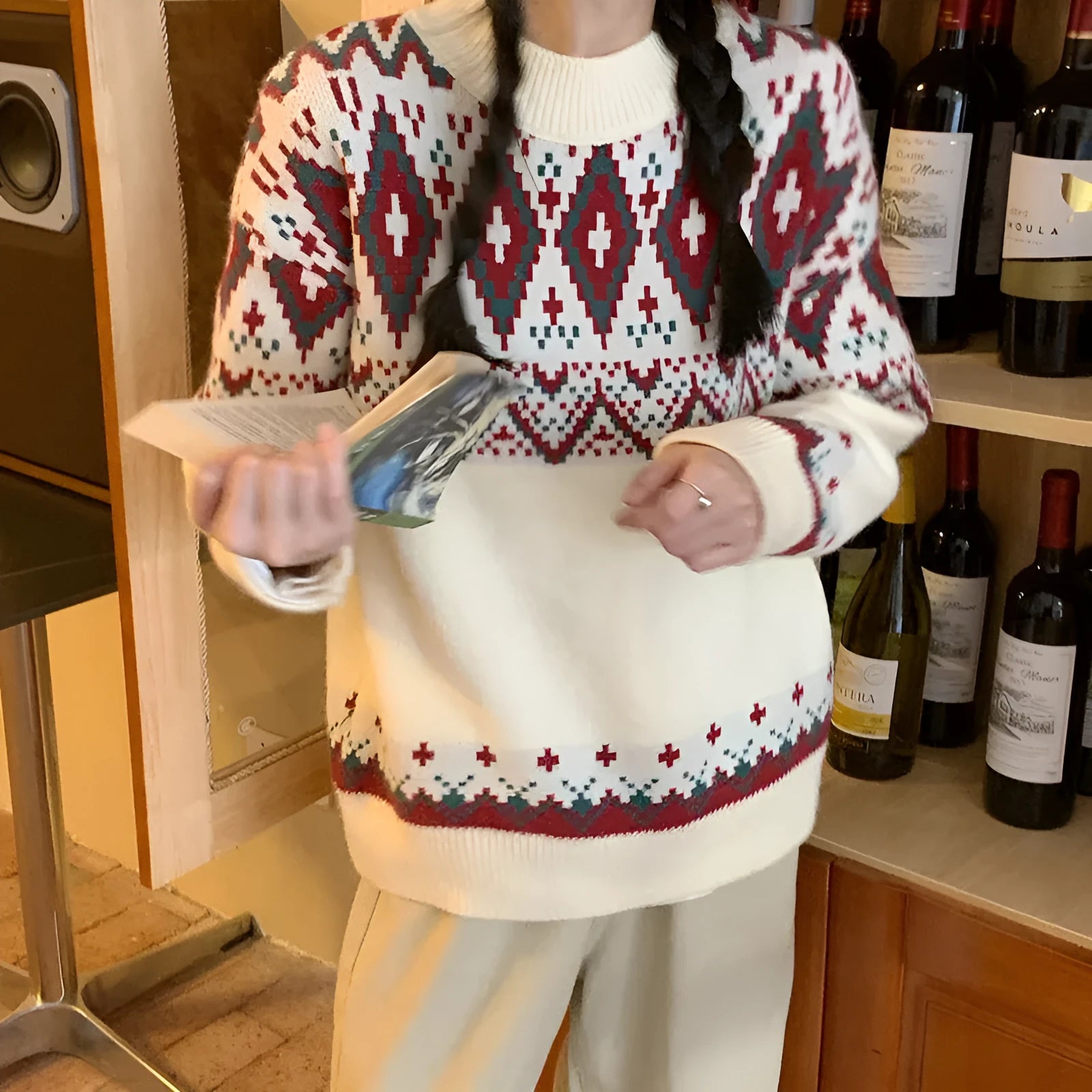 Red and white striped loose-fit knitted pullover with long sleeves on a model.