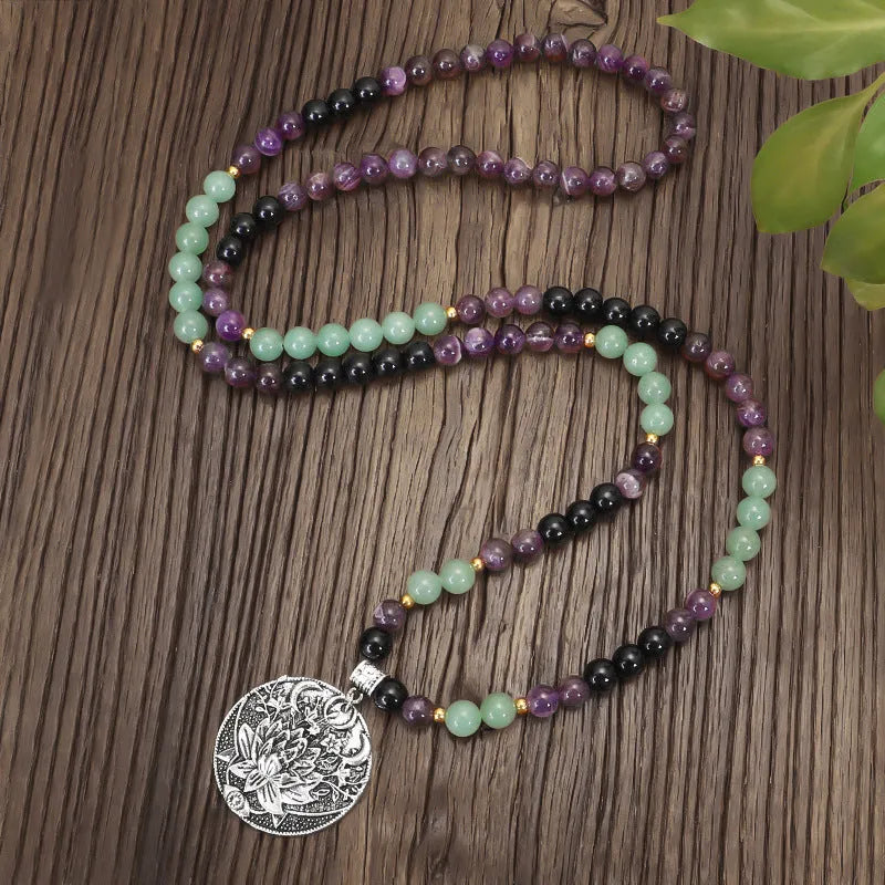 Yoga lotus pendant necklace and bracelet set with stone beads on a white background