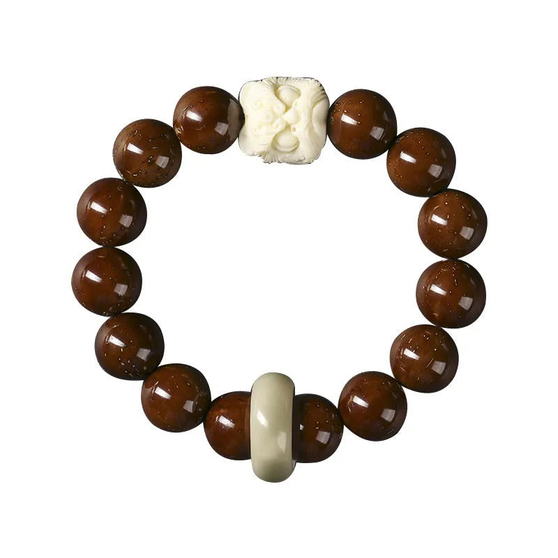 Hand-woven bracelet with 13mm round beads and a carved lion bead centrepiece in ivory nut style.