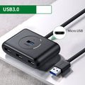 Deep black USB splitter with four ports, Micro USB power port, and indicator light on a desk