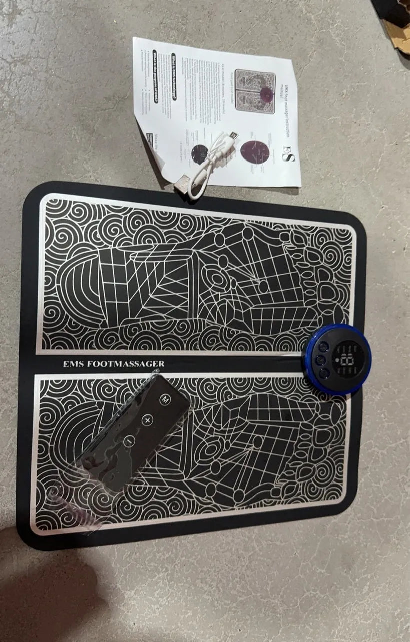 Leather foot massage cushion with LCD screen and wireless remote control on a sofa.