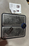 Leather foot massage cushion with LCD screen and wireless remote control on a sofa.