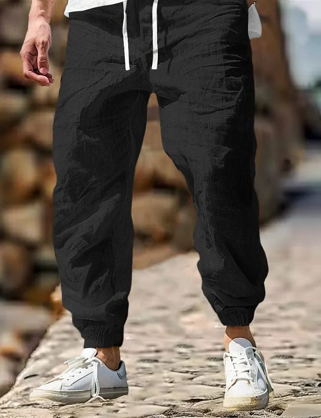 Men's straight-leg cotton trousers with elastic waist in apricot colour on a hanger