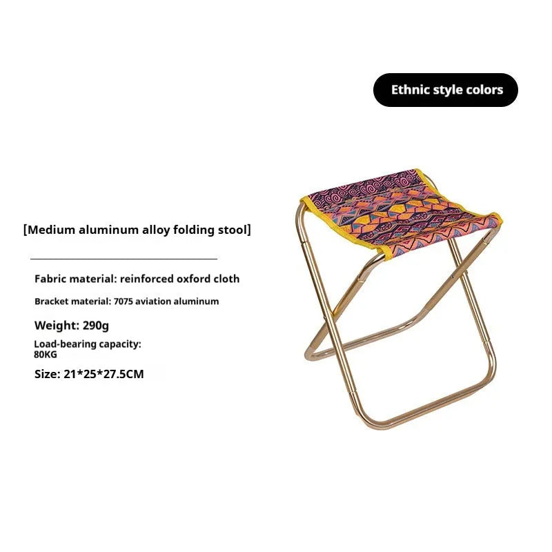 Black ethnic style aluminium alloy folding camping stool shown in use outdoors.