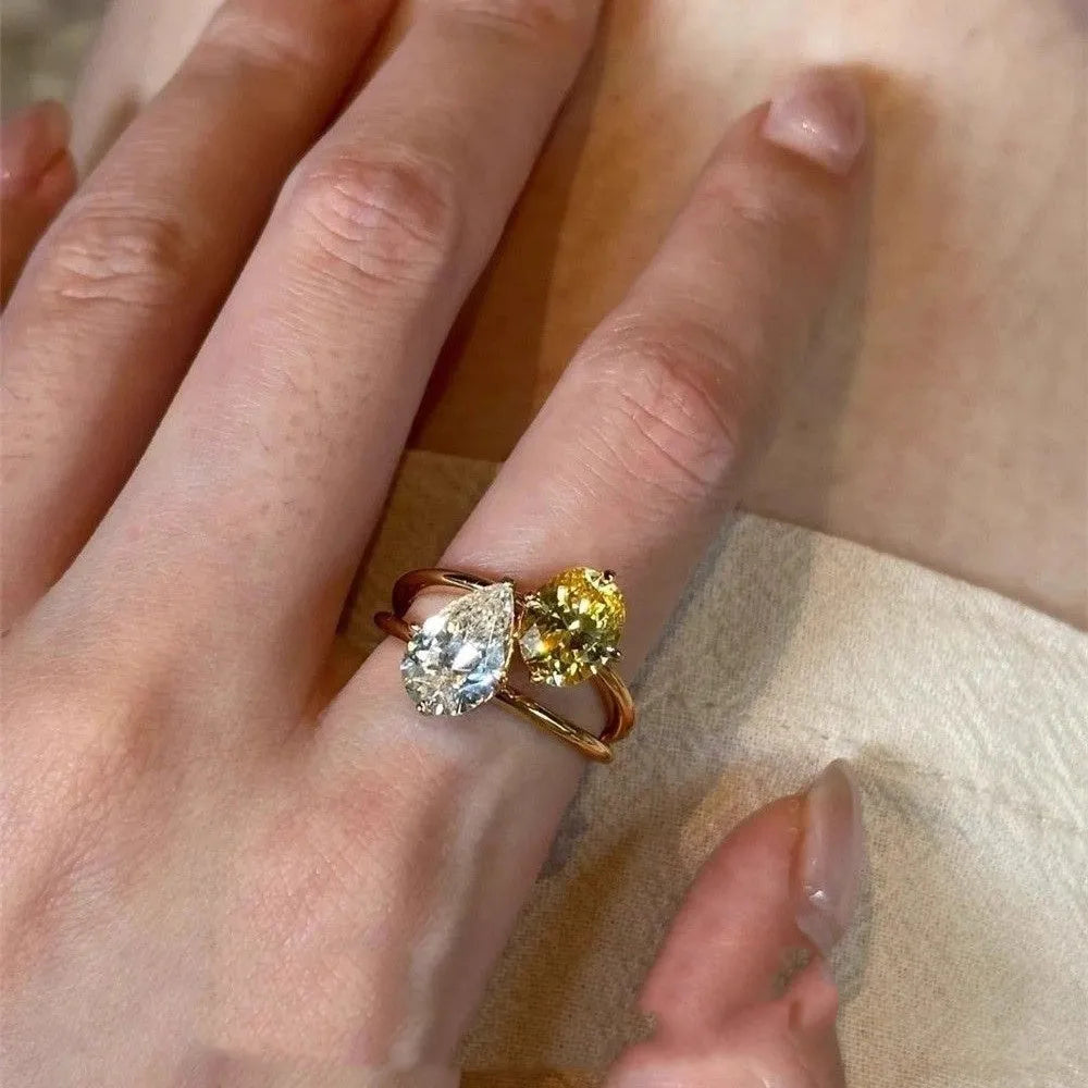 Geometric copper open ring for women with a water drop shape and double Sheng zircon stone setting.