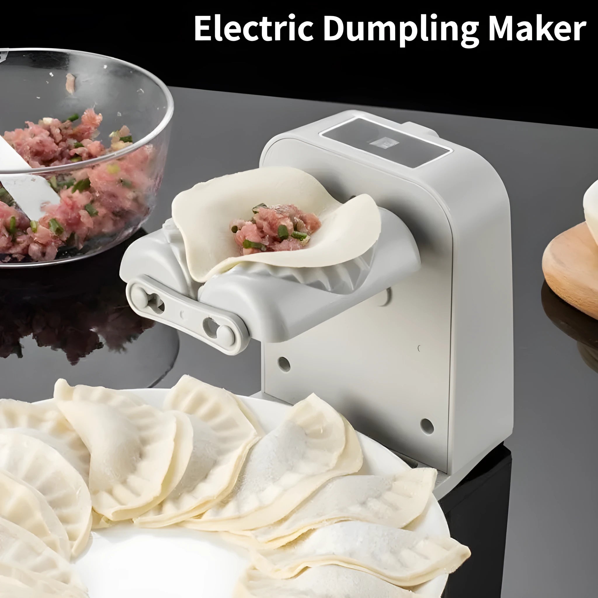 White automatic electric dumpling maker machine with USB charging cable, brush, and spoon on a kitchen counter.