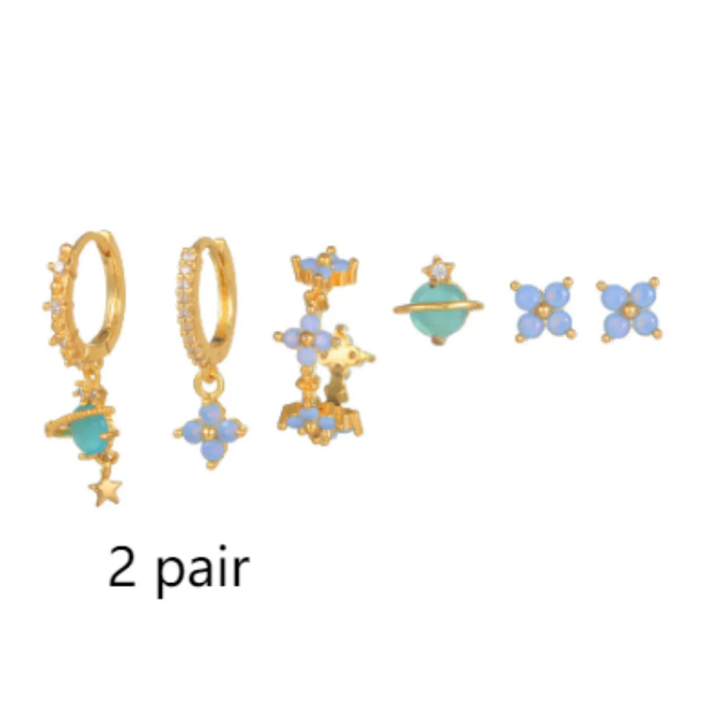 Gold and silver flower-shaped ear studs with zircon mosaic detail on a white background.