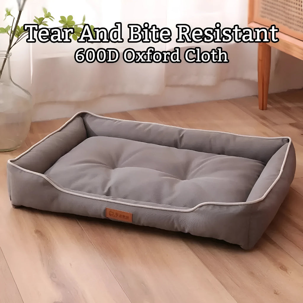 Grey waterproof dog sofa bed with cushioned sides on a wooden floor.