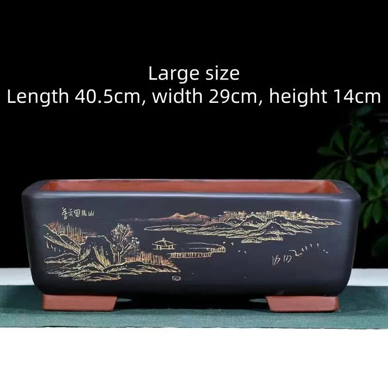A deep blue black handmade rectangular purple clay bonsai pot on a wooden surface.