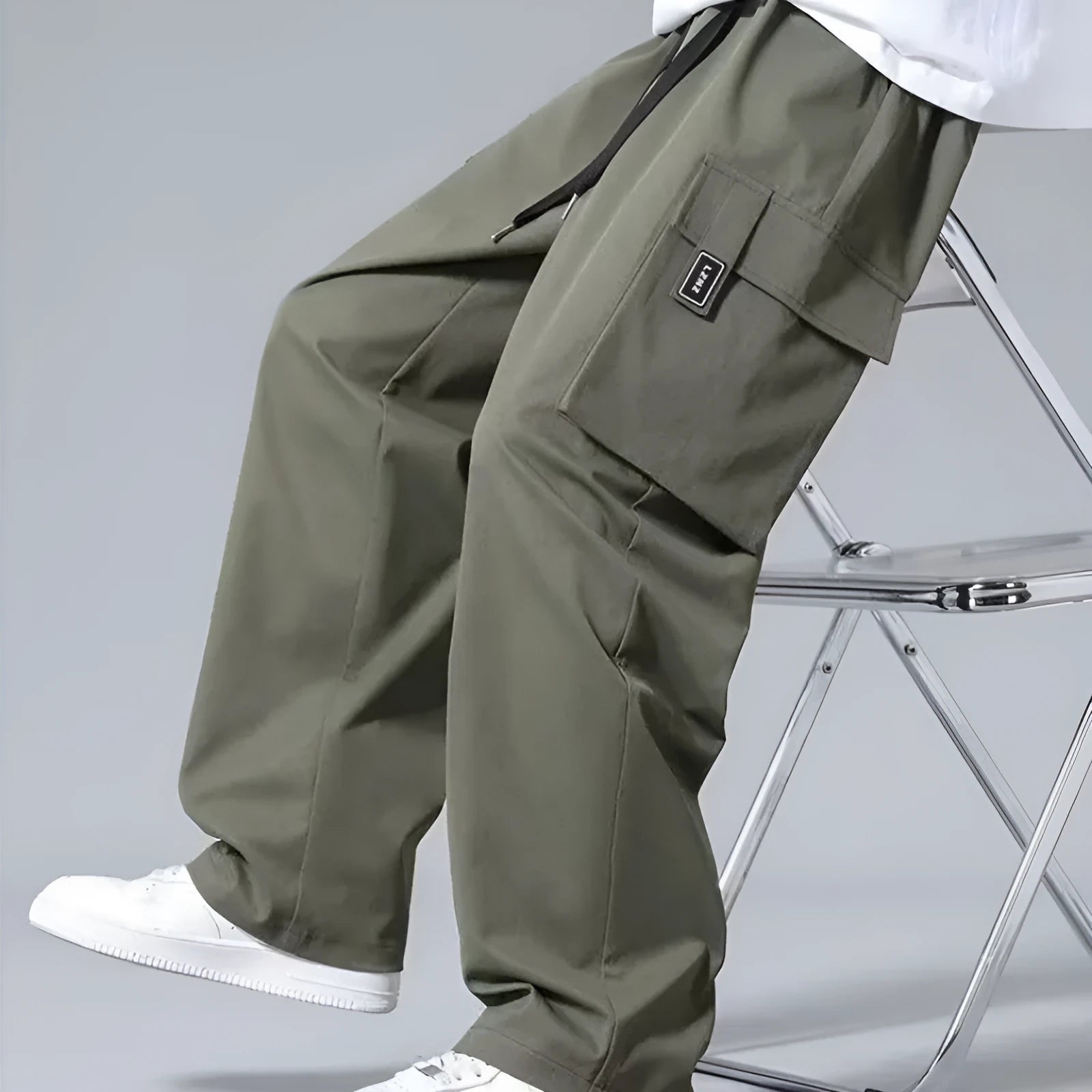 Boy wearing army green straight-leg cargo pants with large side pockets and a drawstring waist.