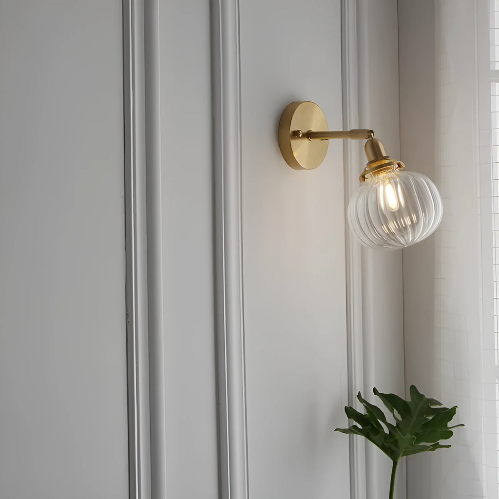 Close-up of a hand-blown water ripple glass wall lamp shade mounted on a white wall, showing its textured surface.