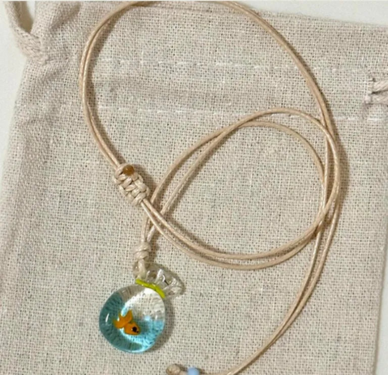 Women's necklace with a colourful skirt joker pendant on a long, braided cotton and linen chain.