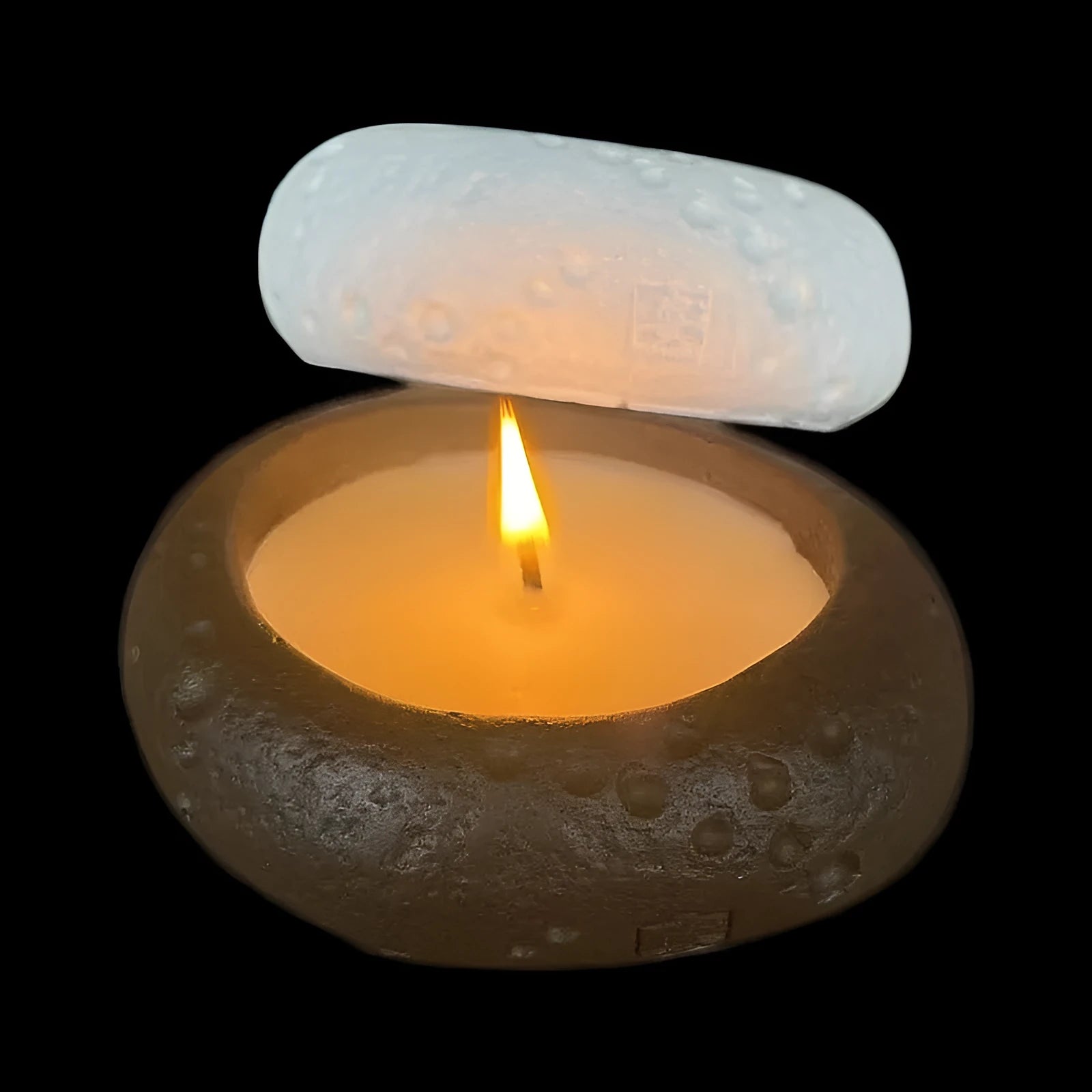White cement candlestick ornament with fair-faced finish holding a candle