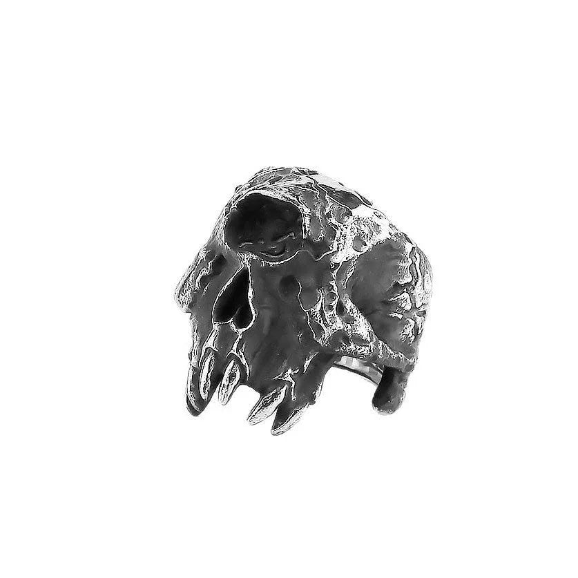 A close-up of a silver-toned alloy ring featuring a detailed one-eyed skull design.