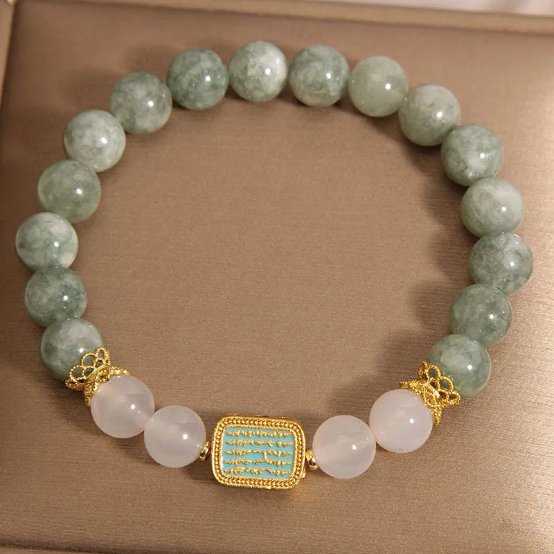 Women's oil green emerald crystal bracelet with five natural gemstones on a wrist.