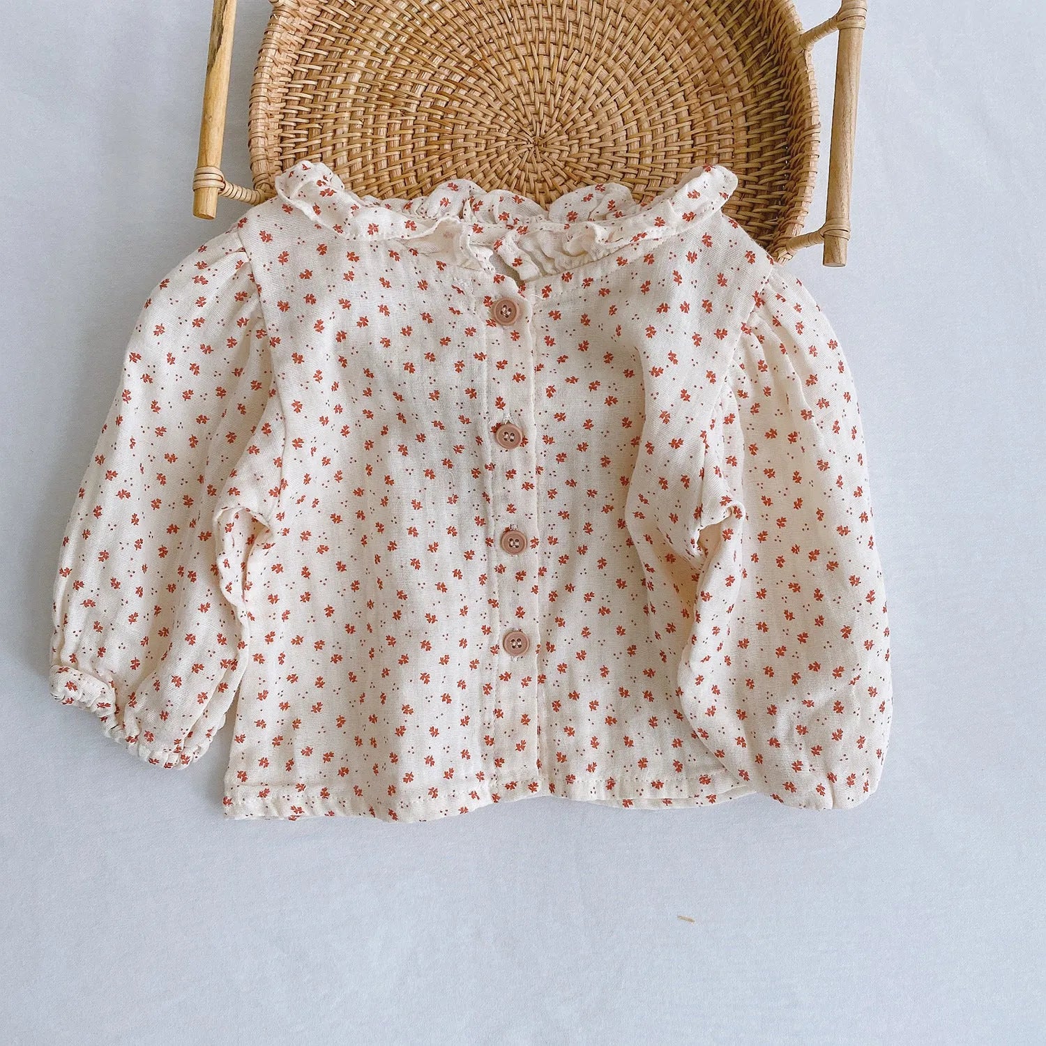 Baby girl wearing a pleated lotus leaf design cotton romper in a triangle climb style.
