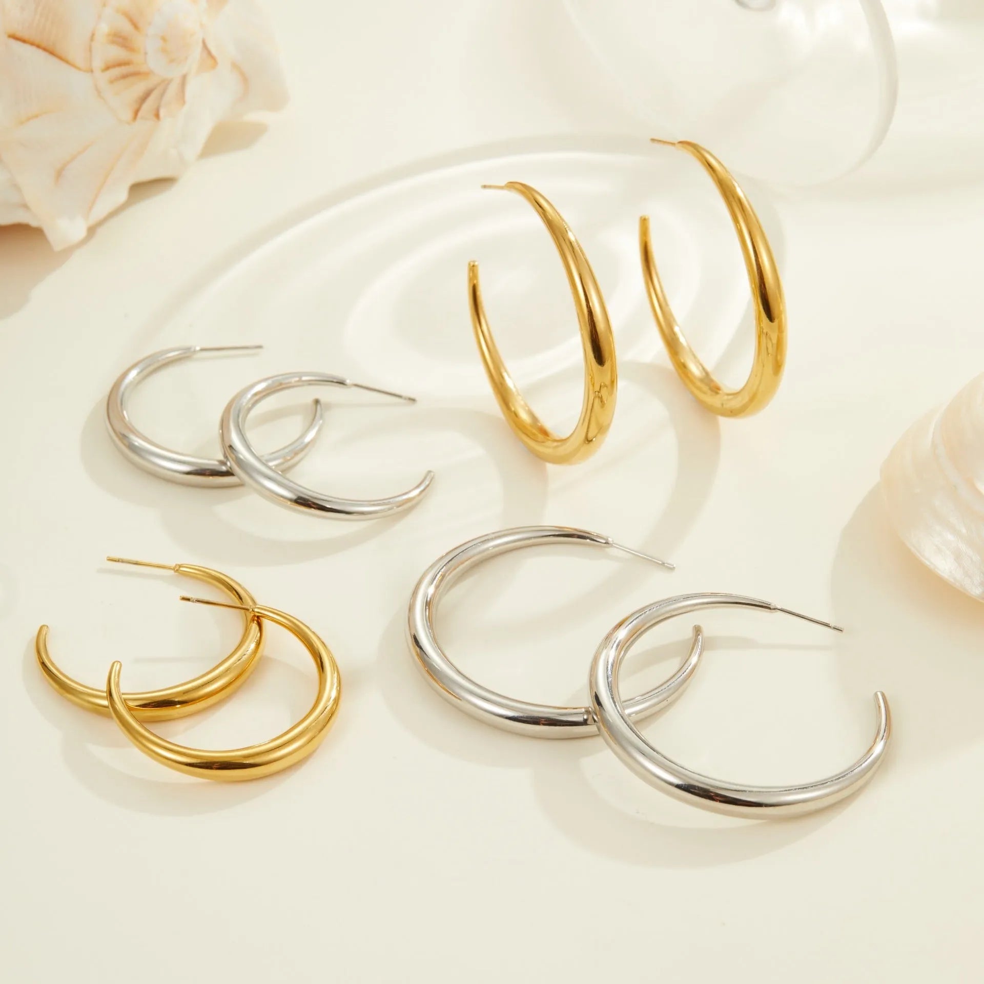 Geometric titanium steel hoop earrings for women in gold and steel finishes with round design elements